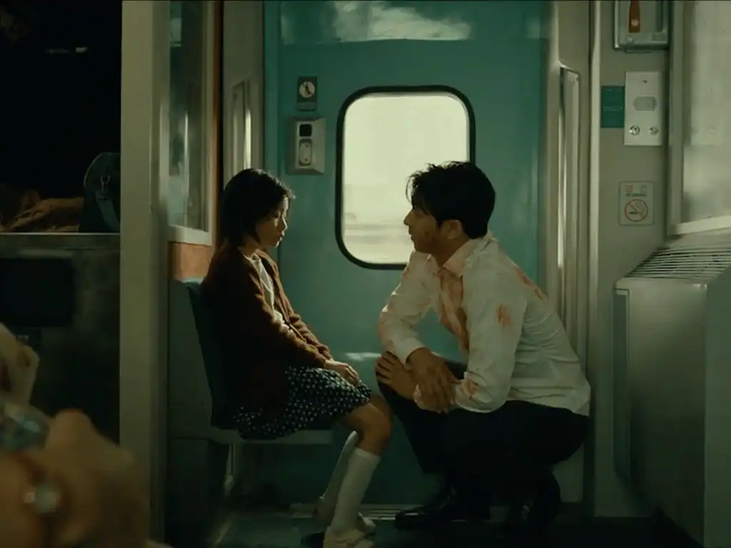 Adegan Seok-woo dan Su-an di dalam kereta dalam film Train to Busan, menggambarkan hubungan ayah dan anak yang berkembang.